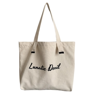 Minimalist canvas tote bag with Lunatic Devil print and black leather handles on white background