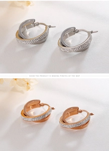 Detail of interlocking hoop earrings in silver and rose gold with zircon inlay