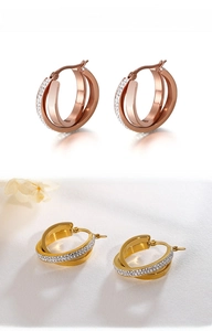 Macro detail of triple interlocking hoop earrings in gold and rose gold with pavé crystals