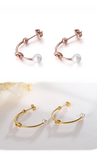 Dettaglio di orecchini a perno a C con perle nelle finiture oro rosa e dorato