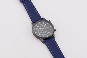 Detail einer minimalistischen Quarzuhr mit blauem Lederarmband und schwarzem Zifferblatt