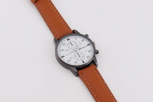 Detail einer minimalistischen Herren-Quarzuhr mit braunem Lederarmband und Zifferblättern