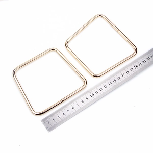 Golden cat ear metal handles for bags shown with a ruler measuring 12cm width