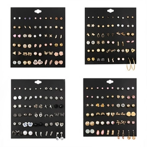 Macro view showing a diverse set of gold and silver earrings on black display boards