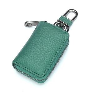 Dettaglio dell'astuccio portachiavi in pelle verde con cerniera argento e moschettone