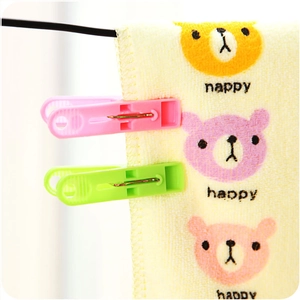 Pink and green plastic clothespins with metal springs for drying laundry and towels