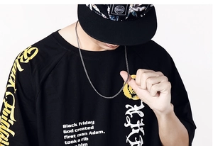 Close-up of a silver-toned metal chain necklace paired with a black graphic streetwear T-shirt
