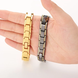 Detailed macro of gold and black magnetic titanium steel therapy bracelets on a palm