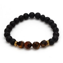 Close-up of black lava rock and brown tiger eye stone beads on an elastic bracelet