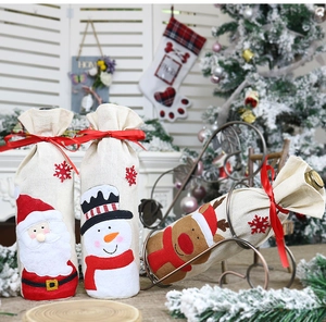 Detail of Christmas wine bottle covers featuring Santa, Snowman and Reindeer in burlap