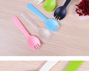 Colorful mini disposable 2-in-1 plastic sporks scattered on a light wooden background
