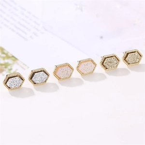 Macro shot of hexagon stud earrings with micro-bead edges and sparkling crystal centers