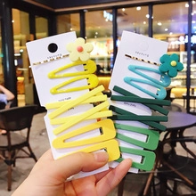 Close-up of matte sunflower hair clips and geometric barrettes in yellow and teal colors