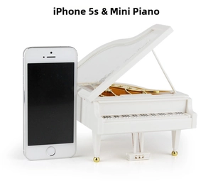 Detailed view of mini white piano music box showing internal golden mechanism and size comparison