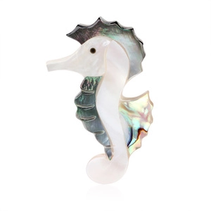 Detailed close-up of a seahorse brooch featuring natural iridescent abalone shell textures