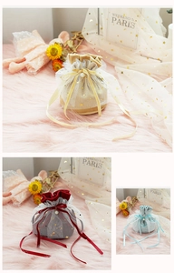 Close-up of velvet wedding candy bags with gold foil mesh lace and pearl charms