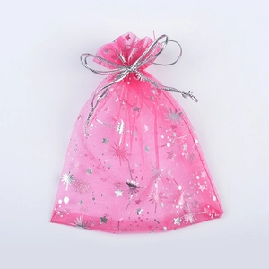 Detailed macro view of a pink organza jewelry gift bag with silver star moon patterns