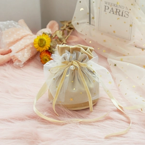 Detail of champagne velvet wedding candy bag with gold star mesh and pearl charm