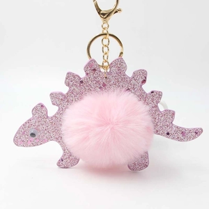 Macro detail of purple glitter dinosaur keychain with soft pink fluffy faux fur pompom