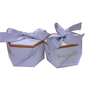 Close-up of hexagonal marble pattern gift boxes with elegant purple ribbon bows