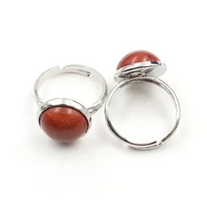 Close-up of adjustable silver rings with round tiger eye and red jasper stone insets