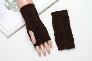 Detail of dark brown cable-knit fingerless gloves with soft textured acrylic yarn finish