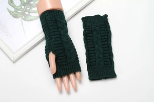 Detail of dark green cable knit fingerless gloves showing texture and hand fit