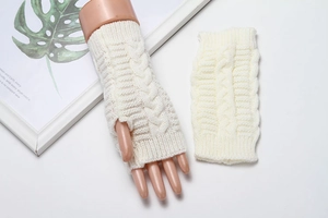 Detail of cable knit pattern on off-white fingerless winter warm wool gloves