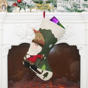 Grüner Weihnachtsstrumpf mit Weihnachtsmann-Motiv am festlich dekorierten Kamin