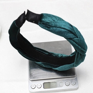 Detail shot showing a dark green velvet braided headband weighing 50.41g on a scale