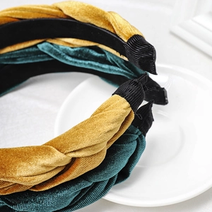 Close-up of ginger and dark green velvet braided headbands with refined woven texture