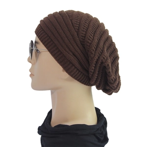 Detail showing the slouchy knit texture and side profile of the dark brown winter beanie
