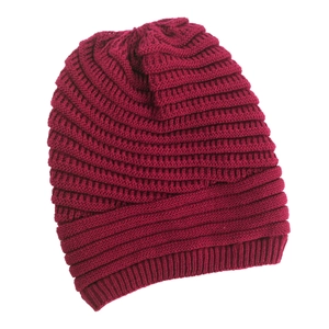 Close-up of wine red knitted beanie showing thick diagonal weave and elastic ribbed cuff