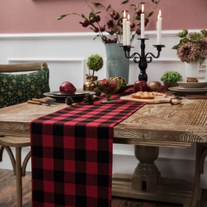 Classic red and black buffalo plaid table runner on a rustic wooden dining table