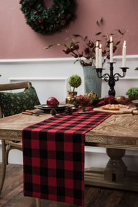 Classic red and black buffalo plaid table runner on a rustic wooden dining table