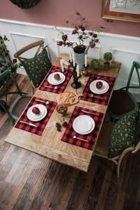 Flat lay of red and black buffalo plaid placemats and green Christmas cushions