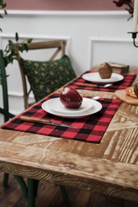 Gros plan d'un set de table à carreaux rouge et noir avec de la vaisselle sur une table en bois
