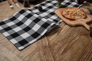 Macro view of black and white plaid table runner on a wooden surface for home decor