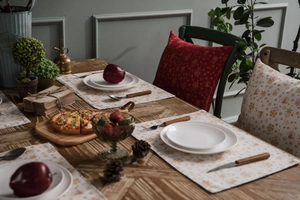 Close-up of red Christmas placemat with golden reindeer and snowflake patterns