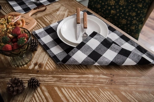 Detail of black and white buffalo check table runner on a rustic wooden table