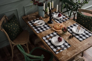 Detail of red and black buffalo plaid table runner on a festive dining table setup
