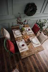 Close-up of white wind bell table runner with gold stamping on a rustic wooden dining table