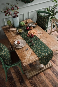Detail of Christmas green table runner with gold snowflake pattern on a vintage wood table