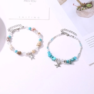 Détail de la chevillère de plage avec pierres turquoise, coquillages et pendentif étoile