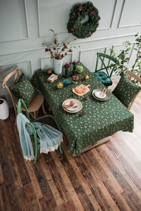 Close-up of festive green rectangular tablecloth with gold snowflake and floral patterns