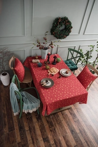Detail of red Christmas tablecloth with gold snowflake prints and matching cushions