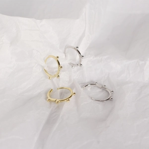 Close-up of minimalist S925 sterling silver hoop earrings with five small beads on white paper
