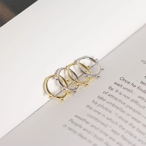 Detail of minimalist S925 sterling silver hoop earrings with beads in gold and silver