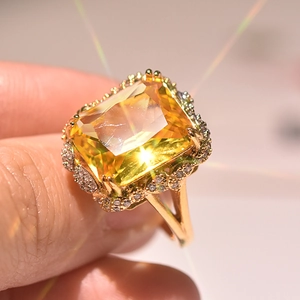 Close-up of luxury gold ring with large champagne square diamond and side accents