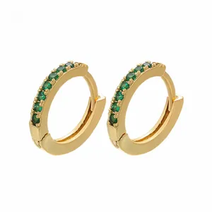 Detailed view of gold-plated huggie earrings with micro-set green zirconia gemstones